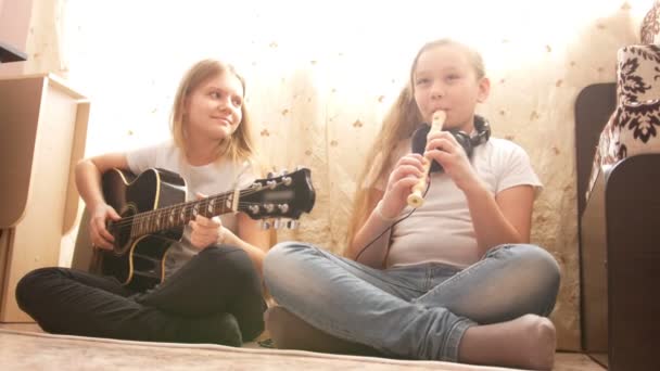 Twee tieners zusters spelende muziekinstrumenten thuis — Stockvideo