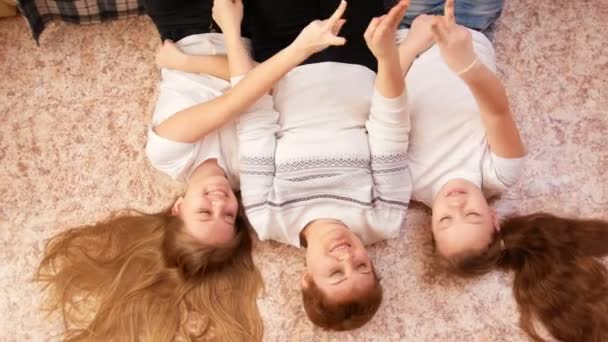 Genç kadın ve onların yakışıklı üstünde oyun oynayan iki kadın genç evde, yerde yatarken portre — Stok video