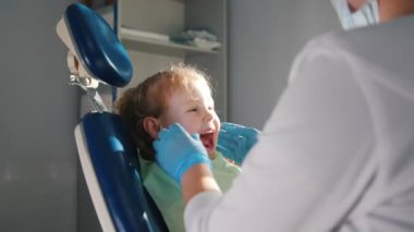 Diş hekimi, temizlik ve gülümseyen ve konuşurken kız childs dişler, sulama stomatologist resepsiyonda gurl
