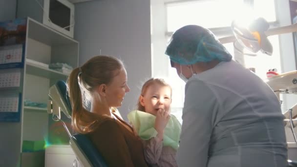Flicka på mottagning hos tandläkaren, tandläkare undersöker childs tänderna, stygg flicka leende — Stockvideo