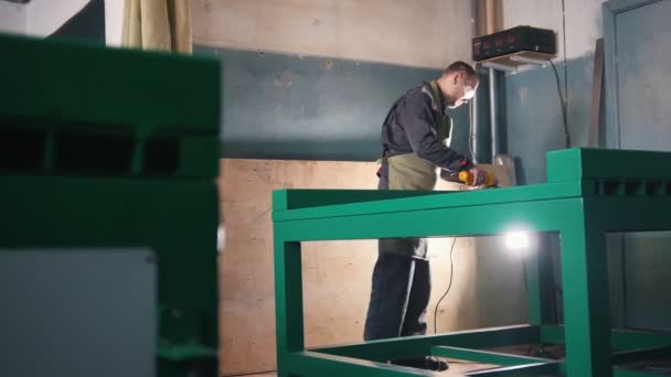 Працівник шліфує сталевий механізм на промисловості — стокове відео