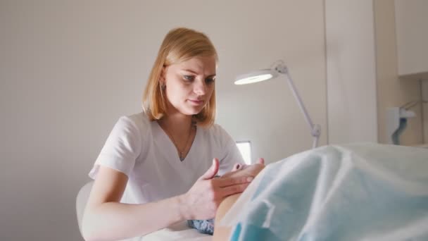 Mulher médico realiza procedimento cosmético - máscara de massagem facial no spa salão de cuidados com a pele — Vídeo de Stock