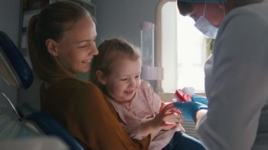 Diş hekimi odasında - doktor anne ile küçük kız kızlar diş inceliyor