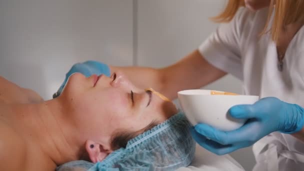 Woman doctor performes cosmetic procedure - mask facial massage at spa salon skincare — Stock Video