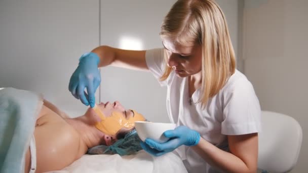 Jeune femme passe traitement masque de fruits facial au salon de beauté — Video