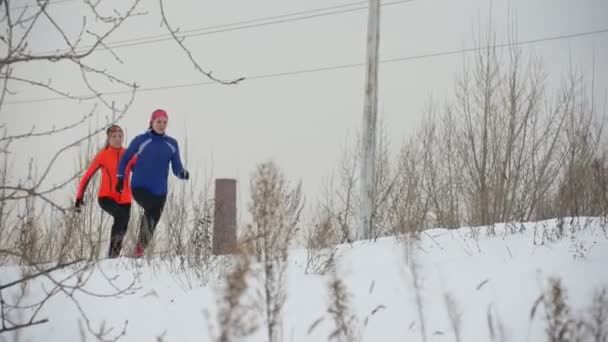 Két fiatal nő fut technikailag télen szabadtéri — Stock videók