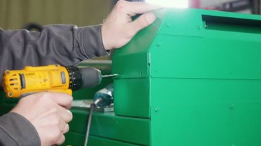 Çalışan bir makine bir el matkap kullanarak Fabrikası'nda tamir