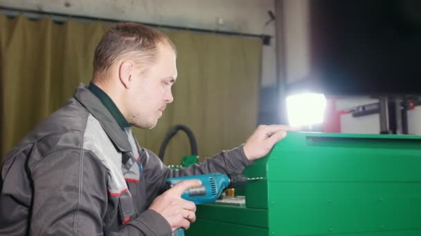 Técnico en la reparación de fábrica de la máquina con taladro manual — Vídeos de Stock