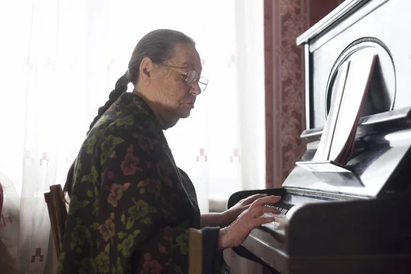 La anciana tocando el piano en casa — Foto de Stock