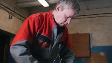 Metal iş parçası bir kumpas ile ölçülür ve işaretleri yapmak işçi