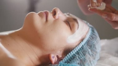 Güzellik Salonu bir kadının yüzüne yakın çekim, bir güzellik maske koyar.