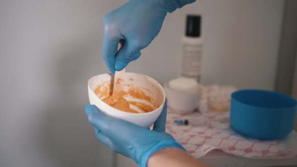 Kosmetyczka mieszania awokado maski w salonie urody za pomocą na twarzy klientów — Wideo stockowe