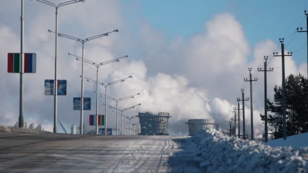 Paesaggio industriale, strada di fabbrica invernale con tubi e lampioni fumanti — Video Stock