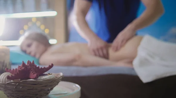 Massage parlor - young girl gets relaxing healing therapy, de-focused — Stock Photo, Image