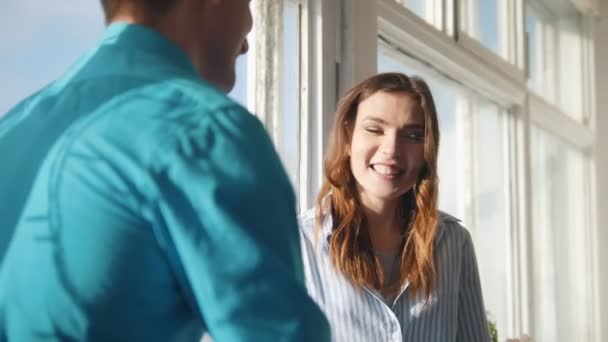 Jonge gelukkige paar zitten op de vensterbank, lachen, flirten, spelen — Stockvideo