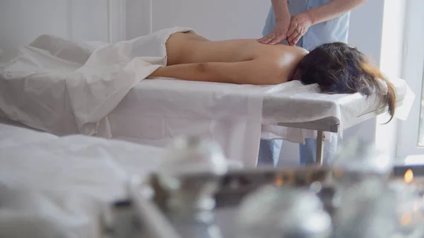 Massagesalon - junges Mädchen bekommt entspannende Heiltherapie für den Rücken — Stockfoto