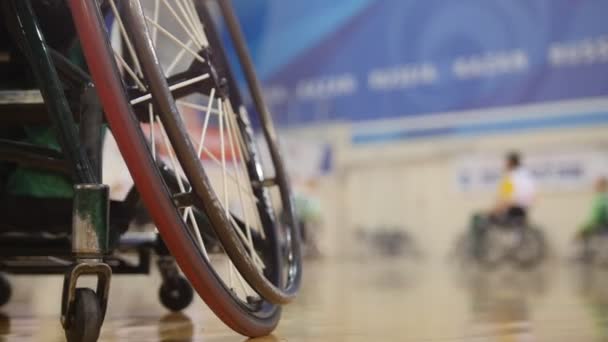 Roue d'un joueur de basket handicapé en fauteuil roulant pendant l'entraînement sportif — Video