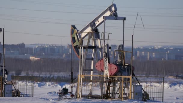 Операційний насос для виробництва сирої нафти на тлі міста — стокове відео