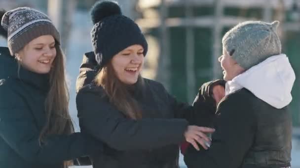 Portret van drie tienermeisjes spelen en elkaar kietelen in de winter buiten — Stockvideo