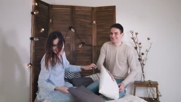 女の子くすぐり男のベッドで戦いを持っている幸せな陽気な愛情のあるカップル — ストック動画