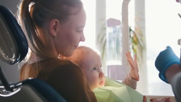 Kleines Mädchen mit Mama im Zahnarztzimmer - Arzt untersucht die Zähne der Mädchen — Stockvideo