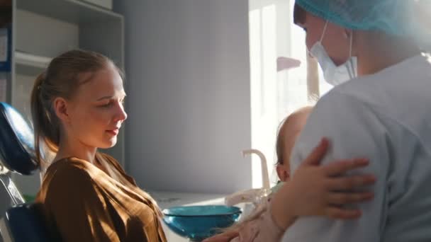 Маленькая девочка с мамой в стоматологическом кресле - ребенок играет — стоковое видео