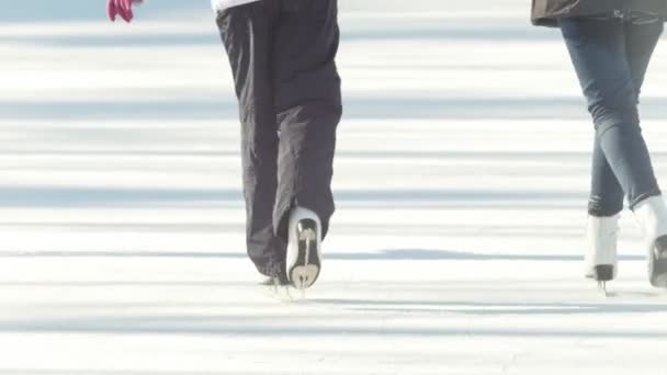 Close-up of girls legs in figure skates skating on the ice rink — Stock Video