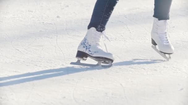 Piernas de una adolescente patinando hábilmente en pista de hielo pública al aire libre, cámara lenta — Vídeos de Stock