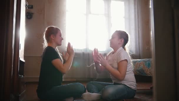 Duas meninas se divertindo e brincando com as mãos no quarto em casa — Vídeo de Stock