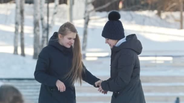 Підлітки ковзають і тримають один одного руками — стокове відео