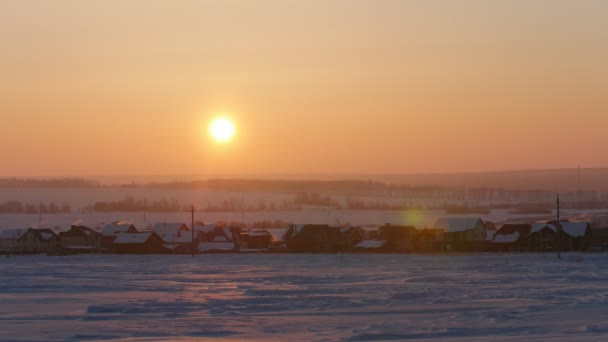 Zonsopgang boven bevroren sneeuw bedekte Russische rustieke landschap, tele — Stockvideo