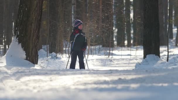 喀山, 俄罗斯-2018年3月: 男孩在冬季森林的滑雪板上运行 — 图库视频影像