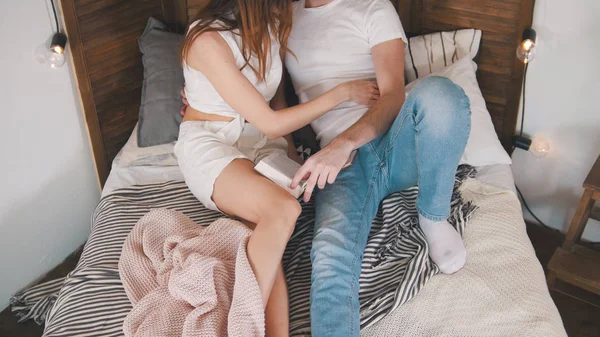 Junger Mann und Mädchen umarmen und küssen sich im Bett — Stockfoto