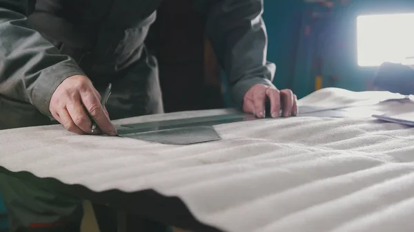 Worker making measurements and marks on a part by means of a ruler — Stock Photo, Image