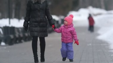 Sevimli küçük kız annesi ile kış sokak yürüyüş