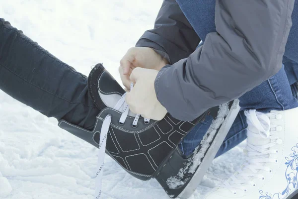 Adolescente menina vestindo patins amarrando patins outro adolescente — Fotografia de Stock