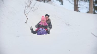 Mutlu anne çocuk kış parkta ile kızak