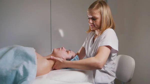 Médico femenino realiza procedimiento cosmético - mascarilla masaje facial en el salón de spa cuidado de la piel — Foto de Stock