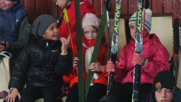 KAZAN, RUSSIA - MARCH, 2018: Children girls sitting on tribunes at the ski marathon — Stock Video