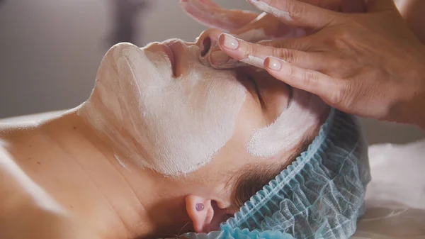 Kvinnliga läkare utövare kosmetiska förfarande - mask ansiktsbehandling massage på spa salong hudvård — Stockfoto