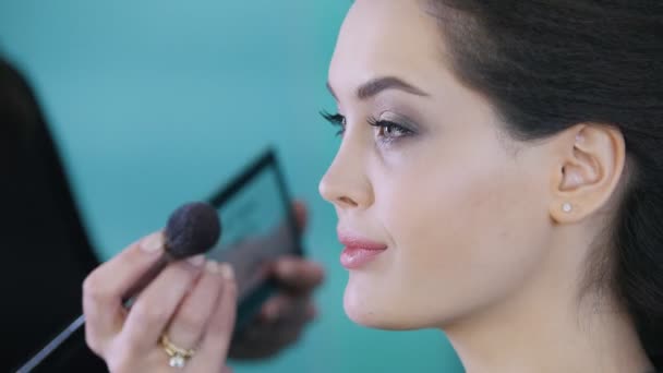 Artista de maquillaje y peluquero trabajando con el cliente en el salón de belleza, aplicando sombra de ojos — Vídeos de Stock