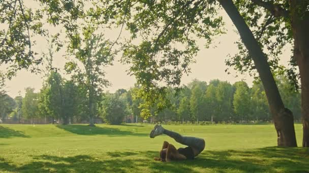 Junge attraktive flexible Frau macht akrobatisches Element im Park am Sommermorgen, Zeitlupe — Stockvideo