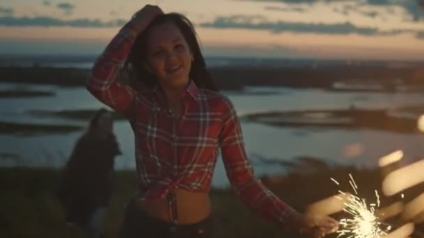 Attractive young woman is dancing with sparkler at evening, slow motion — Stock Video