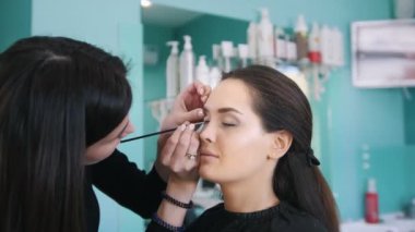 Profesyonel visage sanatçı makyaj güzel kadın için siyah göz kalemi ile yapıyor