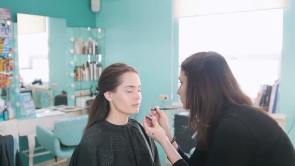 Artista de maquiagem profissional fazendo maquiagem com sombras nos olhos — Vídeo de Stock