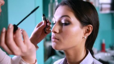 Profesyonel visage sanatçı makyaj güzel kadın için siyah göz kalemi ile yapıyor