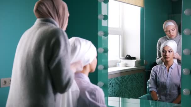 İslam Türban, ayna yakınındaki bir düğün için hazırlanıyor bağlamak için iki Müslüman kadın — Stok video