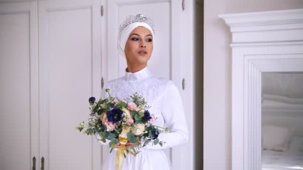 Mooie moslim bruid met make-up in trouwjurk met witte hoofdtooi — Stockvideo