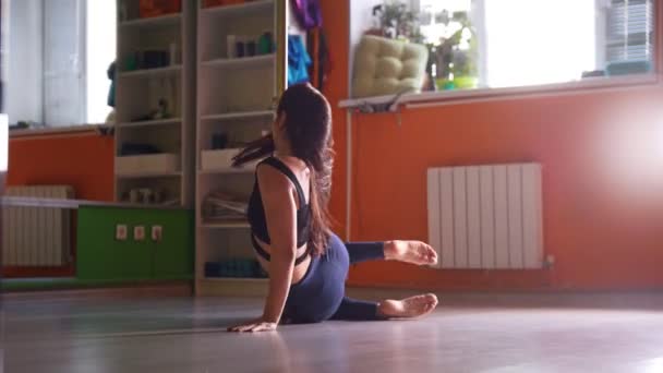 Attraktiva sportig ung kvinna stretching och värmer upp på stång i en fitness klass — Stockvideo