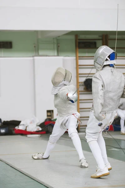 Двоє молодих фехтувальників борються на змаганнях фехтування — стокове фото